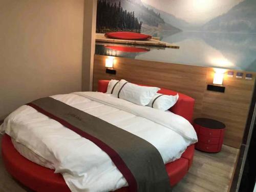 a bedroom with a large bed with a painting on the wall at Thank Inn Chain Hotel Jiangsu Xuzhou Suining County Renmin West Road Store in Xuzhou
