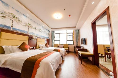 a hotel room with two beds and a desk at JUN Hotels Hunan Changsha Huannghua Airport in Changsha