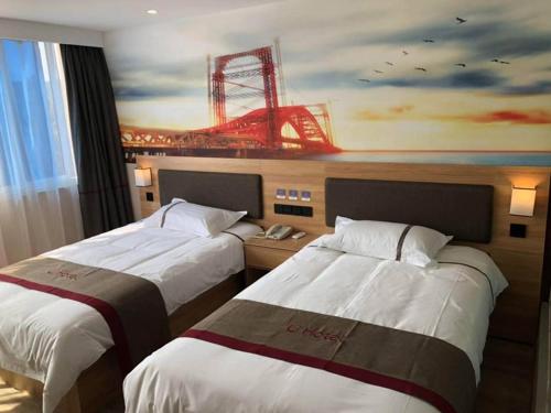 a hotel room with two beds and a painting of a stadium at Thank Inn Chain Hotel Jiangsu Xuzhou Suining County Renmin West Road Store in Xuzhou