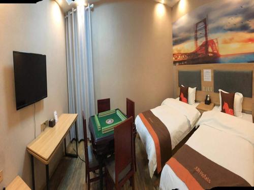 Habitación de hotel con 2 camas y TV en JUN Hotels Hunan Zhuzhou Shifeng District Qingshi Plaza en Zhuzhou