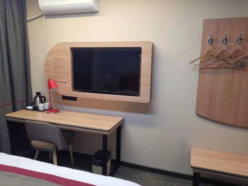 a room with a desk with a tv on a wall at Thank Inn Chain Hotel Shanxi Changzhi Huguan County Bus Station Store in Changzhi