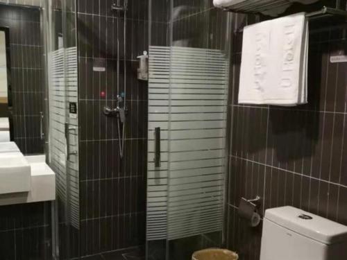 a bathroom with a shower and a toilet and a sink at Thank Inn Chain Hotel Anhui Lu'an Shucheng Yuanda Ganghui in Lu'an