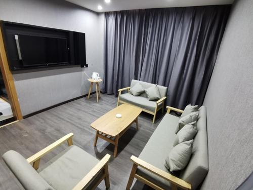a living room with a couch and chairs and a tv at Thank Inn Chain Hotel Shanxi Changzhi Lihou County Lihou Ancient City in Changzhi