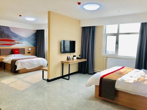 a hotel room with two beds and a flat screen tv at Thank Inn Chain Hotel Shaanxi Baoji Qishan County Zhouwu Road Store in Baoji