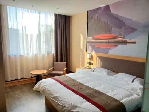 a hotel room with a bed and a painting on the wall at Thank Inn Chain Hotel Taiyang Yingze District Xiyang City Market City Hall in Taiyuan