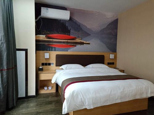 1 dormitorio con 1 cama grande y una pintura en la pared en Thank Inn Plus Hotel Guizhou Zunyi Suiyang County Shixiang Avenue, en Zunyi