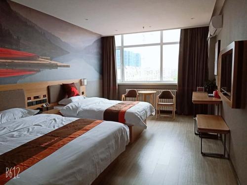a hotel room with two beds and a large window at JUN Hotels Hebei Hengshui Renmin Road 13 Middle School in Hengshui