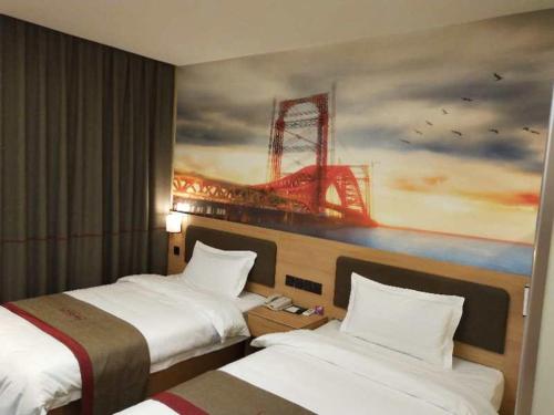 2 Betten in einem Hotelzimmer mit Wandgemälde in der Unterkunft Thank Inn Plus Hotel Shanxi Changzhi District Changzhi College in Changzhi