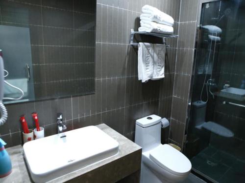 een badkamer met een toilet, een wastafel en een douche bij Thank Inn Chain Hotel Shandong Linyi Lanshan District Liguan Town in Linyi