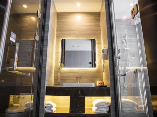 a bathroom with a sink and a toilet and a mirror at Thank Inn Chain Hotel Zhejiang Huzhou Deqing County Xinshi Town Huancheng West Road in Huzhou