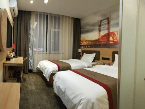 a hotel room with two beds and a painting at Thank Inn Plus Hotel Shanxi Changzhi District Changzhi College in Changzhi