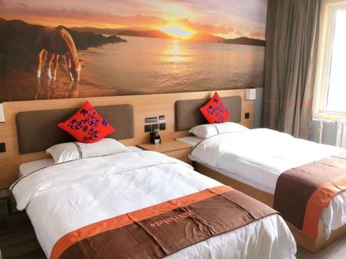 una habitación de hotel con 2 camas y una pintura de un caballo en JUN Hotels Dezhou Decheng District Hubin South Avenue Wanda Plaza, en Dezhou