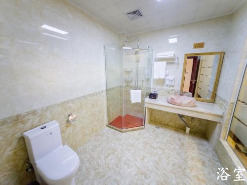 een badkamer met een douche, een toilet en een wastafel bij JUN Hotels Hunan Changsha Huannghua Airport in Changsha