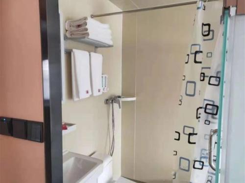 een badkamer met een douche en een wastafel bij Thank Inn Chain Hotel Shandong Dezhou Lingcheng District Lingzhou Road Ginza in Dezhou
