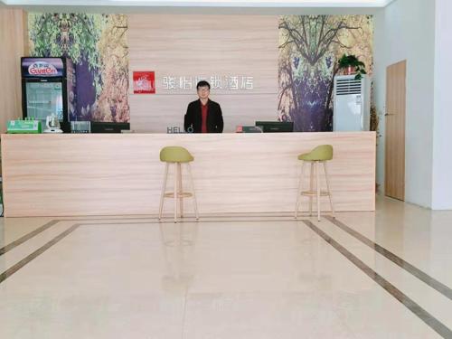 a man standing at a counter in a store at JUN Hotels He'nan Zhoukou Shenqiu Zhaofeng Avenue in Zhoukou
