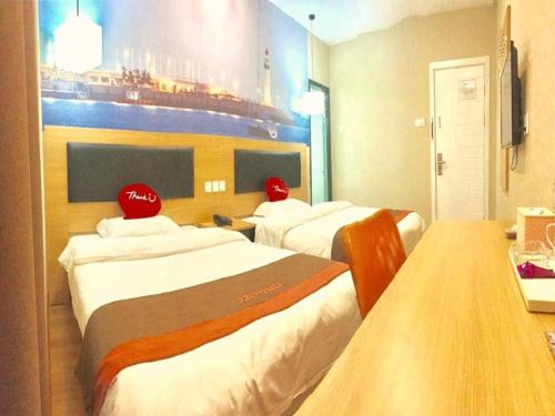 a hotel room with three beds with red hats on them at JUN Hotels ujian Fuzhou Jinan District Railway Station in Fuzhou