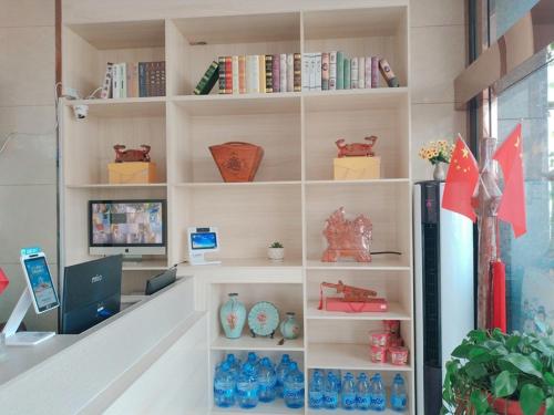 a book shelf with vases and books on it at JUN Hotels Shandong Tai'an Daiyue District Tai'an High Speed Railway Station Store in Tai'an