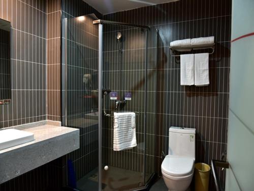 a bathroom with a shower and a toilet and a sink at Thank Inn Chain Hotel Guizhou Tongren Bijiang District High-speed Railway Station Qingshui Avenue Store in Tongren