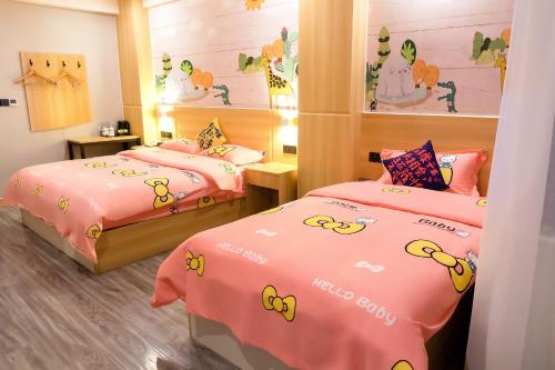 2 camas en una habitación con kitty Hello en JUN Hotels Sichuan Suining Chuanshan District Heping Road, en Suining