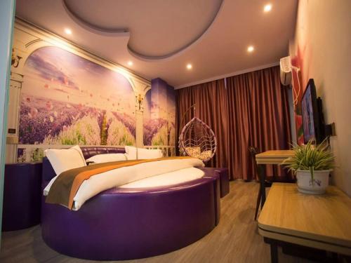 une chambre avec un grand lit et une table dans l'établissement JUN Hotels Jiangsu Wuxi Jiangyin Changjing Coach Station Store, à Wuxi