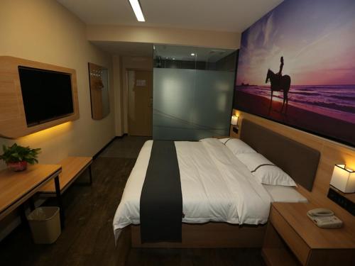 1 dormitorio con 1 cama grande y una pintura en la pared en Thank Inn Chain Hotel Shanxi Xinzhou Xinfu District Xuefu East Street Heping Square en Xinzhou