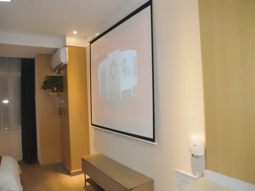 a large screen hanging on a wall in a room at JUN Hotels Shandong Liaocheng Eco-Tech Development Zone Contmporary International Plaza in Liaocheng