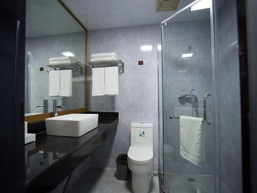une salle de bain avec un lavabo, des toilettes et une douche dans l'établissement JUN Hotels Jiangsu Wuxi Jiangyin Changjing Coach Station Store, à Wuxi