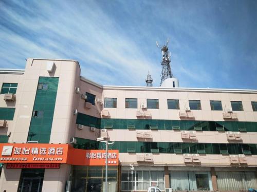 un edificio con una antena encima en JUN Hotels Hebei Hengshui Taocheng Railway Station Square West Side, en Hengshui