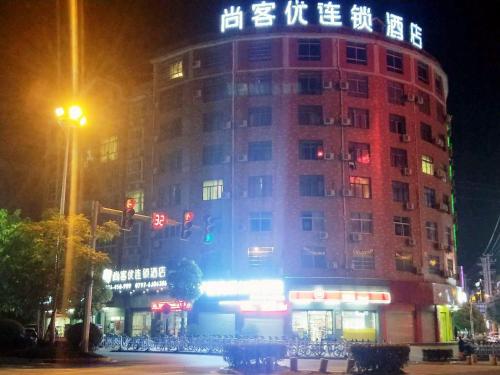 a building with a sign on top of it at night at Thank Inn Chain Hotel Jiangxi Ganzhou Yudu County Railway Station Store in Ganzhou