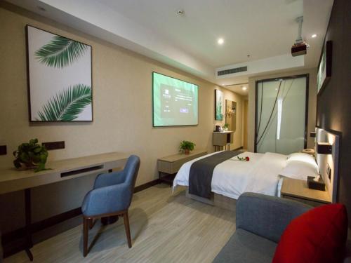 une chambre d'hôtel avec un lit et un écran de projection dans l'établissement Up and In Shanxi Taiyuan Zonggai Shifanqu, à Taiyuan