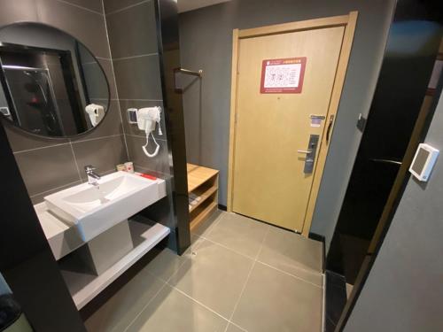een badkamer met een wastafel en een spiegel bij Thank Inn Chain Hotel Hebei Handan Ci County Xinshiji in Handan