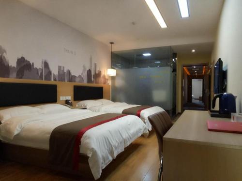 Cette chambre comprend 2 lits et une télévision. dans l'établissement Thank Inn Chain Hotel Chizhou Zhanqian District Railway Station, à Chizhou