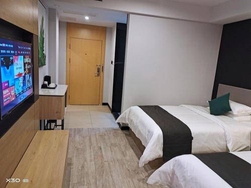 Habitación de hotel con 2 camas y TV de pantalla plana. en Up And In Guangxi Nanning Shanglin County Longhu Xincheng en Shanglin