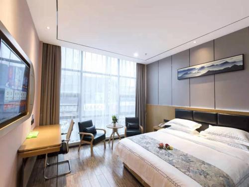 Habitación de hotel con cama grande y TV en Thank Inn Chain Hotel Ganzhou Zhanggong District Wanxiang City, en Ganzhou