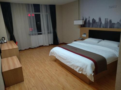YushuにあるThank Inn Chain Hotel Qinghai Yushu County Kangba Commercial Cityのホテルルーム内のベッドルーム1室(大型ベッド1台付)