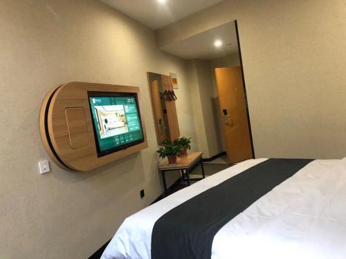 a bedroom with a bed and a flat screen tv at Thank Inn Chain Hotel Liaocheng Yanggu County Fucheng in Liaocheng