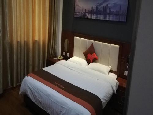揚州的住宿－骏怡连锁江苏扬州开发区八里镇店，一间位于酒店客房内的带大床的卧室
