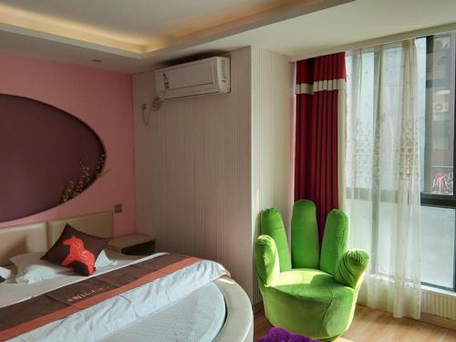 a bedroom with a green chair next to a bed at JUN Hotels Anhui Suzhou Lingbi County Riyue Star City Laidi Shopping Street Store in Suzhou