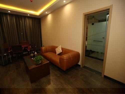 sala de estar con sofá de cuero y mesa en Thank Inn Chain Hotel Shanxi Xinzhou Xinfu District Xuefu East Street Heping Square, en Xinzhou