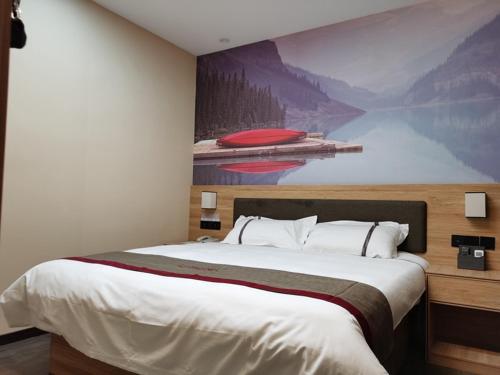 een slaapkamer met een groot bed en een schilderij aan de muur bij Thank Inn Chain Hotel Jiangsu Kunshan Lujia Town Baiyang Bay Logistics Center in Suzhou