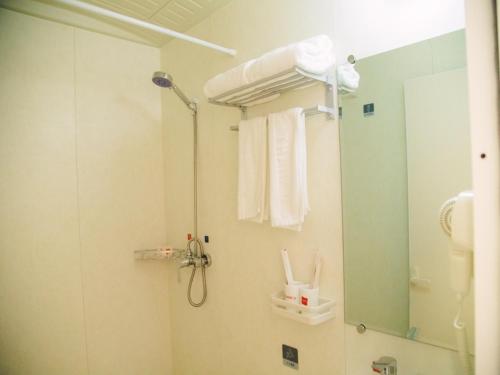 een badkamer met een douche en een spiegel bij Thank Inn Chain Hotel Sanmenxia Wanda Plaza New Gantang Road in Sanmenxia