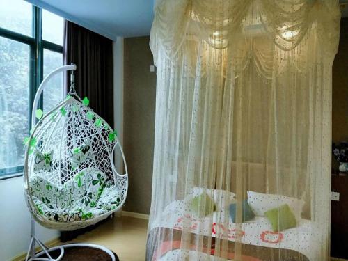 1 dormitorio con cama, cortina y ventana en JUN Hotels Anhui Huangshan Tunxi District Huangshan Old Street, en Huangshan