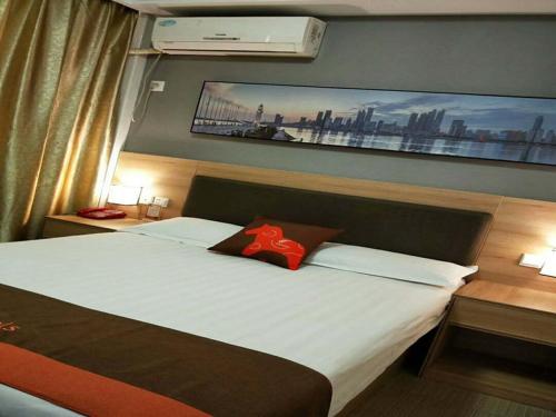 - une chambre avec un grand lit et une peinture murale dans l'établissement JUN Hotels Lu'an Huoshan County Huayuan Road, à Lu'an