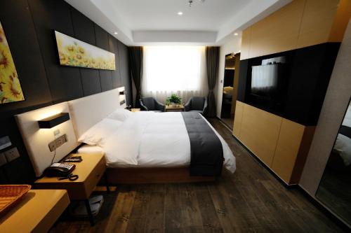 a hotel room with a bed and a television at Thank Inn Chain Hotel Shandong Linyi Junan County Longshan Road in Linyi