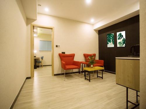 a waiting room with orange chairs and a table at Up And In Baotou Qingshan District Central International in Baotou