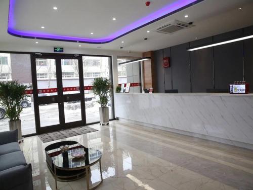 vestíbulo con bar en un edificio con iluminación púrpura en Thank Inn Chain Hotel Shanxi Xinzhou Xinfu District Xuefu East Street Heping Square, en Xinzhou