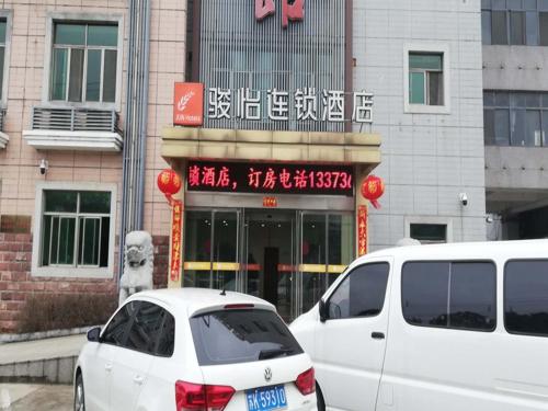 揚州的住宿－骏怡连锁江苏扬州开发区八里镇店，两辆白色汽车停在大楼前