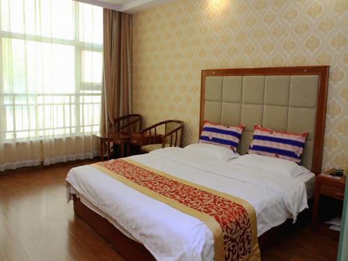 A bed or beds in a room at JUN Hotels Zhangjiakou Qiaodong District Yu'er Mountain Taihe Home
