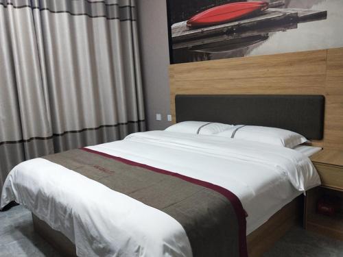 Schlafzimmer mit einem großen Bett und einem roten Kissen in der Unterkunft Thank Inn Chain Hotel Shandong Linyi Linshu County Cangshan South Road in Linyi