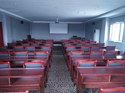 an empty lecture room with red chairs and a whiteboard at JUN Hotels Hebei Hengshui Taocheng Railway Station Square West Side in Hengshui